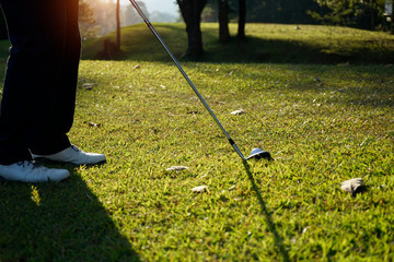 Blurred golfer playing golf in the evening golf course, on sun set evening time.