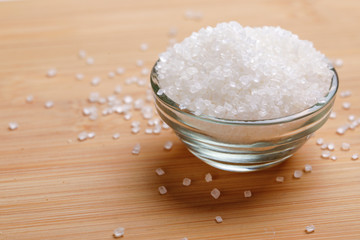 sugar in glass bowl on wooden background 