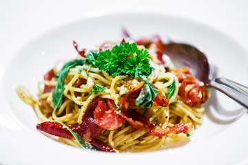 Stir-Fried Spaghetti Crispy Bacon and Dried Chili in white plate