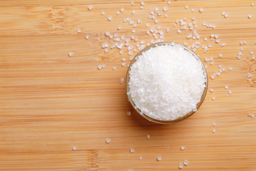sugar in glass bowl on wooden background 
