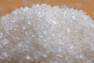 sugar in glass bowl on wooden background 