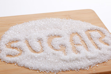 A word "SUGAR" made of with  Sugar Seed on wooden board 