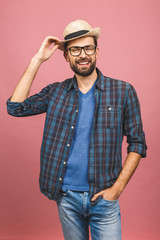 Picture of happy young man standing isolated over pink background. Looking at camera.