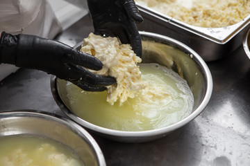 Italian hard cheese silano or caciocavallo in cheesemaker hands. The home-made cheese maker produces handmade caciocavallo. Concept: tradition, italy, mozzarella.The process of making mozzarella.