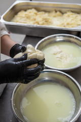 Italian hard cheese silano or caciocavallo in cheesemaker hands. The home-made cheese maker produces handmade caciocavallo. Concept: tradition, italy, mozzarella.The process of making mozzarella.