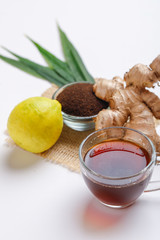 Black tea with lemon and ginger over white background 