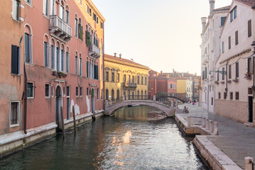 Fototapeta na wymiar Venice, Italy. Old houses and low bridges over the canal on the street