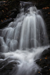 Beautiful waterfall in Scottish Highlands.Motion of flowing water.Cascade with texture and dark wet rocks in background.Tranquil landscape scene.