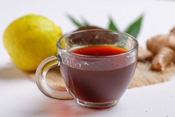Black tea with lemon and ginger over white background 