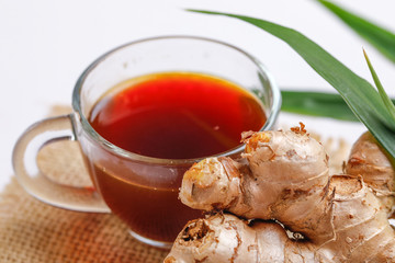 Black tea with lemon and ginger over white background 