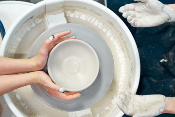Women making ceramic pottery, concept for workshop and master class, four hands close-up, focus on potters, palms with pottery. Creative hobby concept. Earn extra money, side hustle