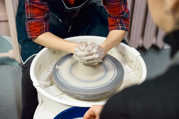 Woman making ceramic pottery on wheel, hands closeup. Concept for woman in freelance, business, creative hobby. Earn extra money, side hustle