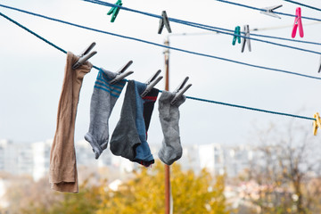 A clothespin hangs on the washing line. A rope with clean linen and clothes outdoors on the day of the laundry. Against the background of green nature and sky.