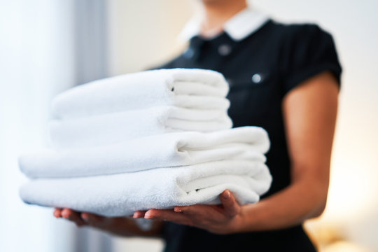 Maid with fresh towels in hotel room