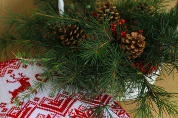Winter, Christmas decor with pine branches, woven basket, conifer cones, columbian cones, on wooden background
