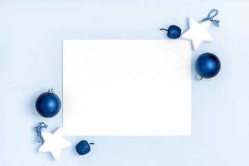 New Year and Christmas frame composition. Blank sheet of paper on blue background. Top view, flat lay, copy space