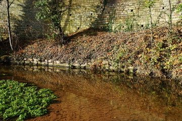 Alte Stadtmauer im Sonnenlicht mit Flusslandschaft