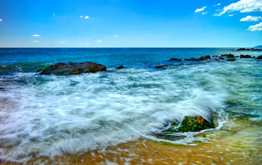 Beautiful landscape with rocks and sea waves on a sunny beach
