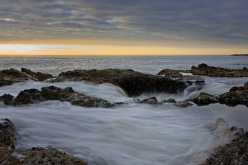 Obraz premium Smooth flowing water draining into Thor's Well during dramatic sunset Cape Perpetua Oregon Coast