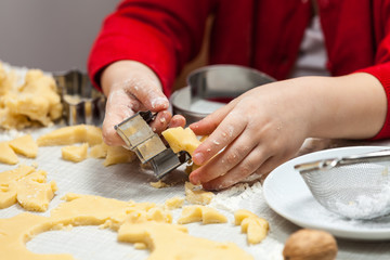 Kind sticht Plätchen aus ausgerolltem Teig aus