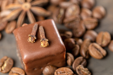 Appetizing food background. Sweets, coffee beans and spices close-up on dark backdrop. 