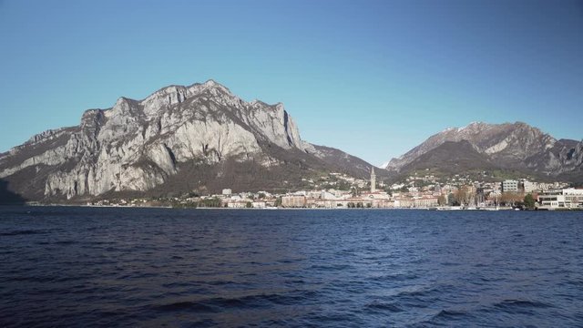The city of Lecco and the mountains around it on a windy day seen from Malgrate