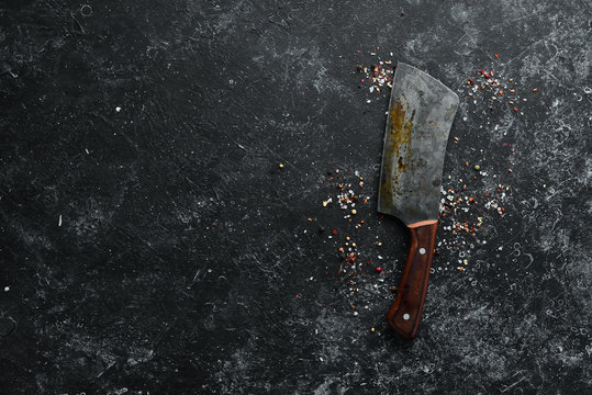 Old knife on black stone background. Top view. Free space for your text.