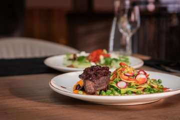 Roasted beef with berries sauce garnished with vegetables