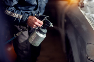 Applying paint to a car part with a spray gun