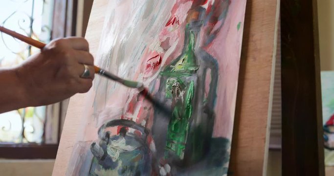 Elderly woman painting for hobby. Senior person at art school. Leisure activity, lifestyle, recreation, passion, fun. Old woman holding brush and palette, creating artwork. Close-up of brush and color