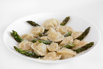 Meat dumplings with parmigiano and asparagus on white plate, isolated.