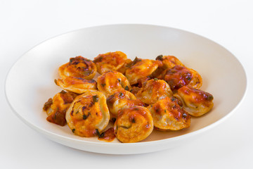 Russian food pelmeni, fried meat dumplings on white plate, with tomato sauce, isolated