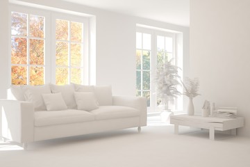 Fototapeta premium Stylish room in white color with sofa and autumn landscape in window. Scandinavian interior design. 3D illustration