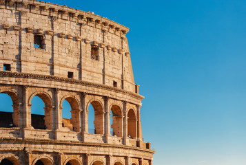 Obraz premium Colosseum or Coliseum ancient ruins background blue sky Rome, Italy