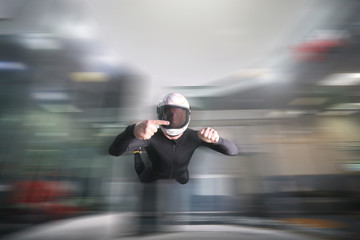 One finger. Fly men show one finger. Sky diver in black suit. Teampleat skydiver.