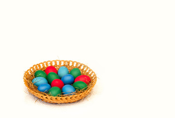 Fototapeta na wymiar Easter colored eggs in a basket, blue eggs, red eggs on a white isolated background
