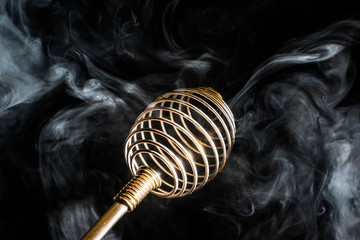 whisk for whipping in smoke, on a black background