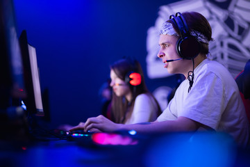 Team professional gamer playing tournaments online games computer with headphones, red and blue