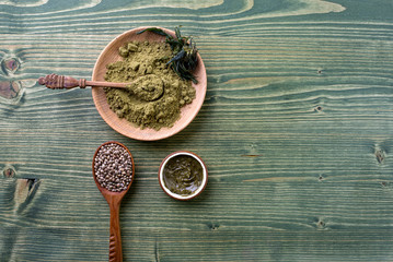 Composition with jar of hemp protein powder, cannabis seeds, organic cream on wooden table. Space for text