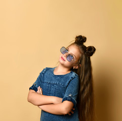 Cute girl in jeans sundress and sunglasses posing on camera.