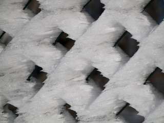 Frozen snow on a chainlink fence