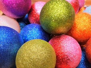 Beautiful Colorful shiny Christmas ball background. Top view. New year decoration. Christmas background with shiny decoration balls. Sparkling decoration balls for new year tree. Selective focus 