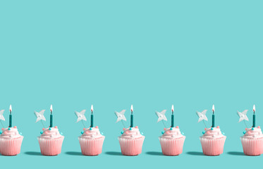 Tasty celebratory cupcakes with decorative lit candles