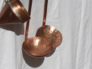 Traditionally handcrafted copper kitchen utensils against white background . Tuscany, Italy