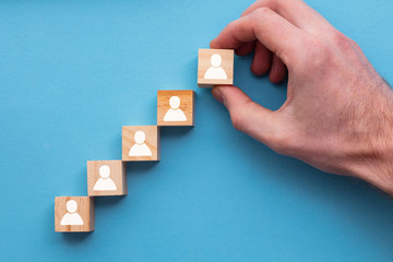 Hand adding a new team member to a group. Business management concept