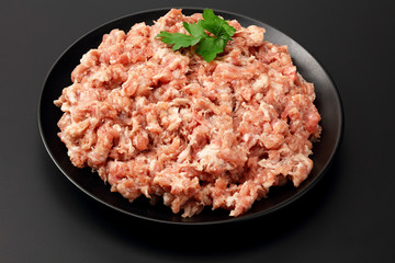 Mince. Ground meat with spices on black background. Top view