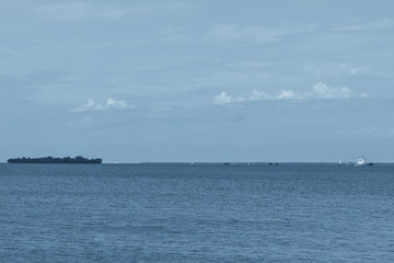 Gulf of Finland coast in classic blue. Island and sailboats on the horizon in classic blue.