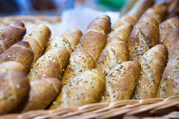 Baguettes in early morning sunlight by a windowsill in a bakery with other breads
