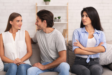Girl Looking At Boyfriend Flirting With Woman Sitting On Sofa