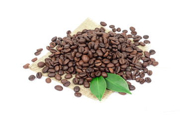 Coffee beans and green leaves on a white background.